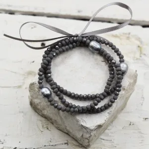 Grey beaded bracelet with grey pearls and a detailed knot